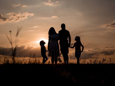 a family standing in a field at sunset